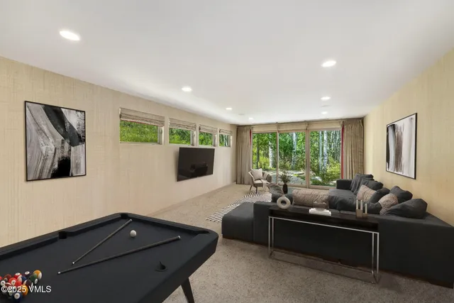 a living room with furniture and floor to ceiling window