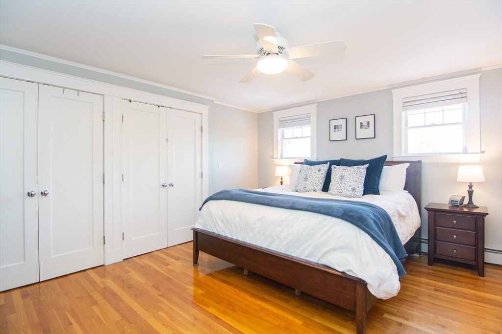 1289 Walnut Street Newton, MA 02461 - Photo 16 of 42 a spacious bedroom with a bed and a chandelier
