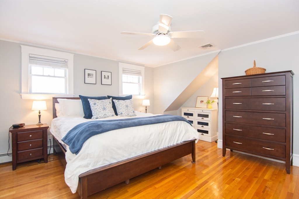 1289 Walnut Street Newton, MA 02461 - Photo 17 of 42 a spacious bedroom with a bed and a chandelier