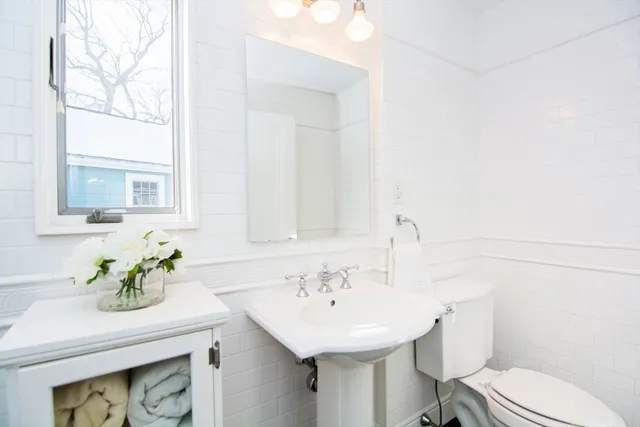a bathroom with a sink toilet and a mirror