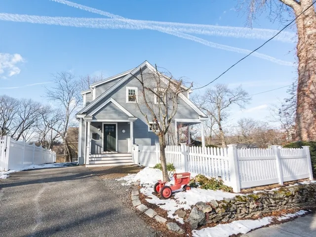 a view of a white house with a large windows and a yard