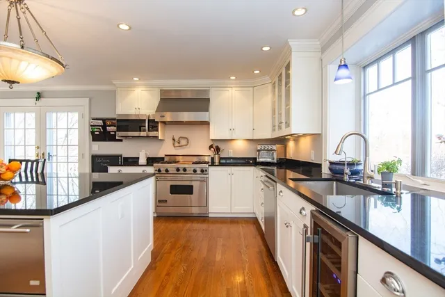 a kitchen with granite countertop a sink a counter top space stainless steel appliances and cabinets