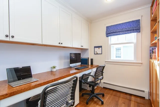 a view of a workspace with furniture and a window