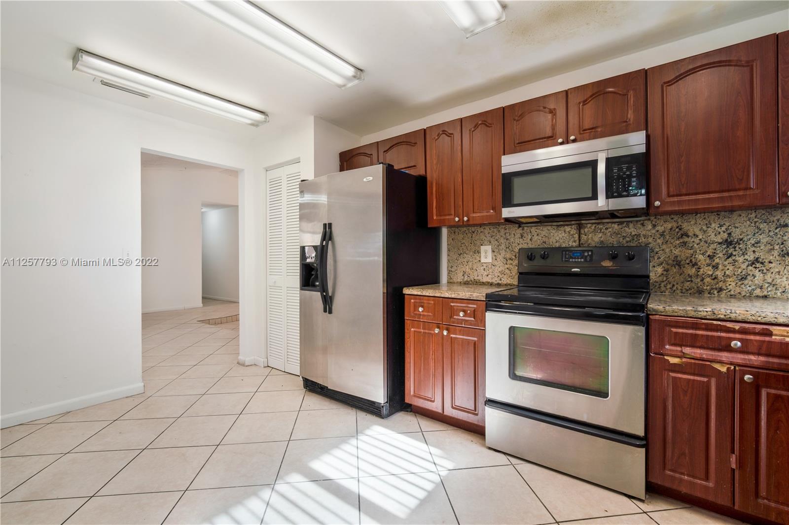 14121 Southwest 47th Street Miami, FL 33175 - Photo 11 of 45 a kitchen with stainless steel appliances granite countertop a refrigerator stove and microwave
