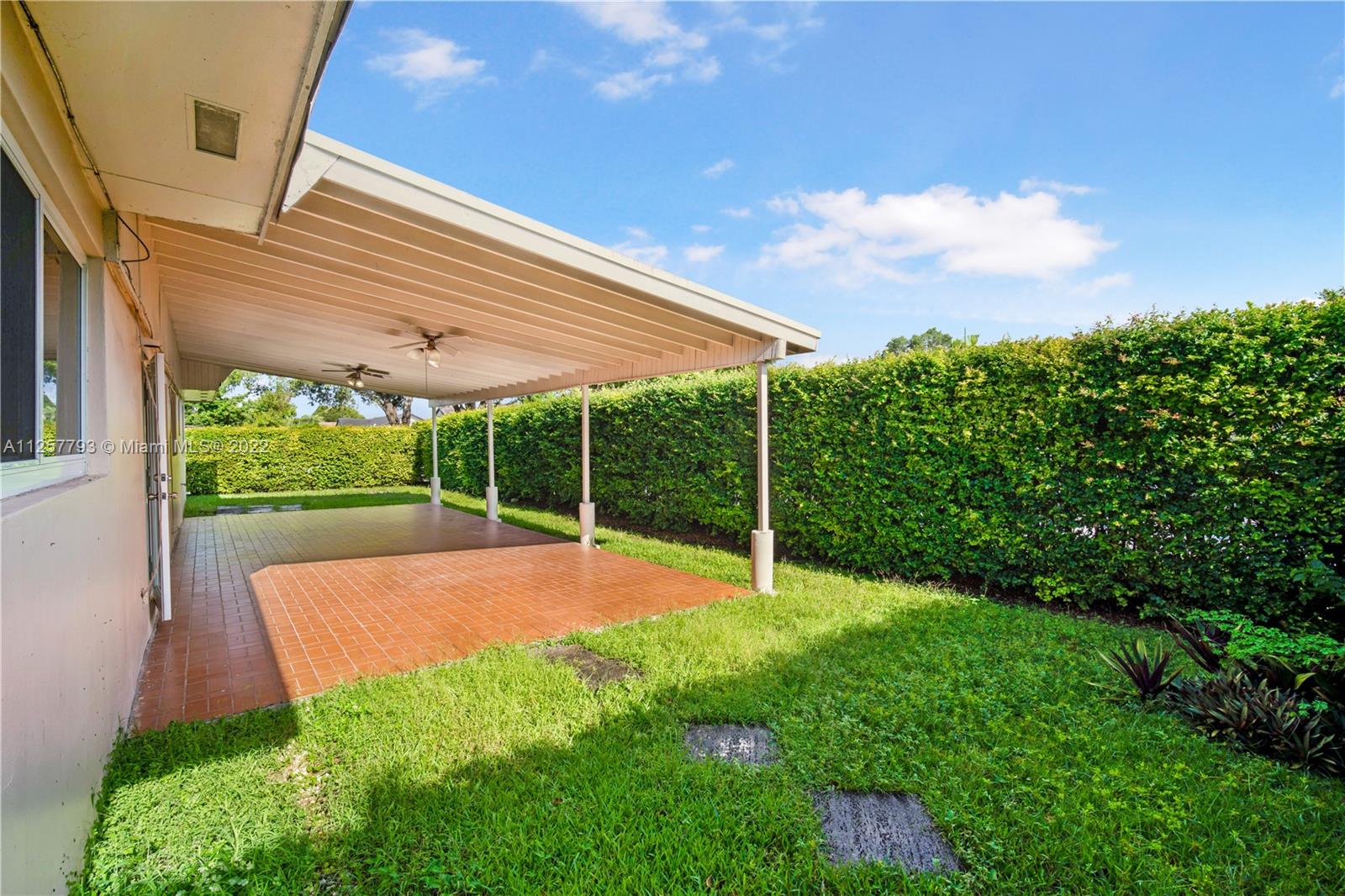 14121 Southwest 47th Street Miami, FL 33175 - Photo 20 of 45 a view of a backyard with table and chairs under an umbrella