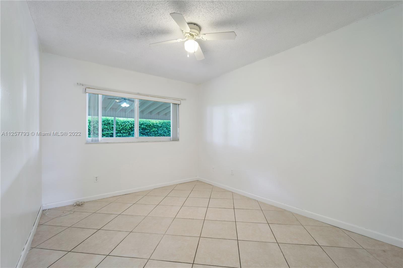 14121 Southwest 47th Street Miami, FL 33175 - Photo 31 of 45 an empty room with a ceiling fan and a window