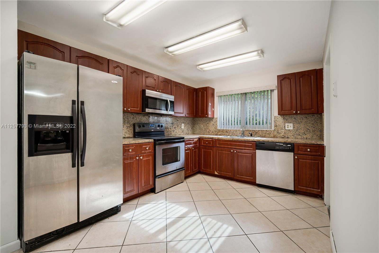 14121 Southwest 47th Street Miami, FL 33175 - Photo 10 of 45 a kitchen with stainless steel appliances granite countertop a refrigerator sink and stove