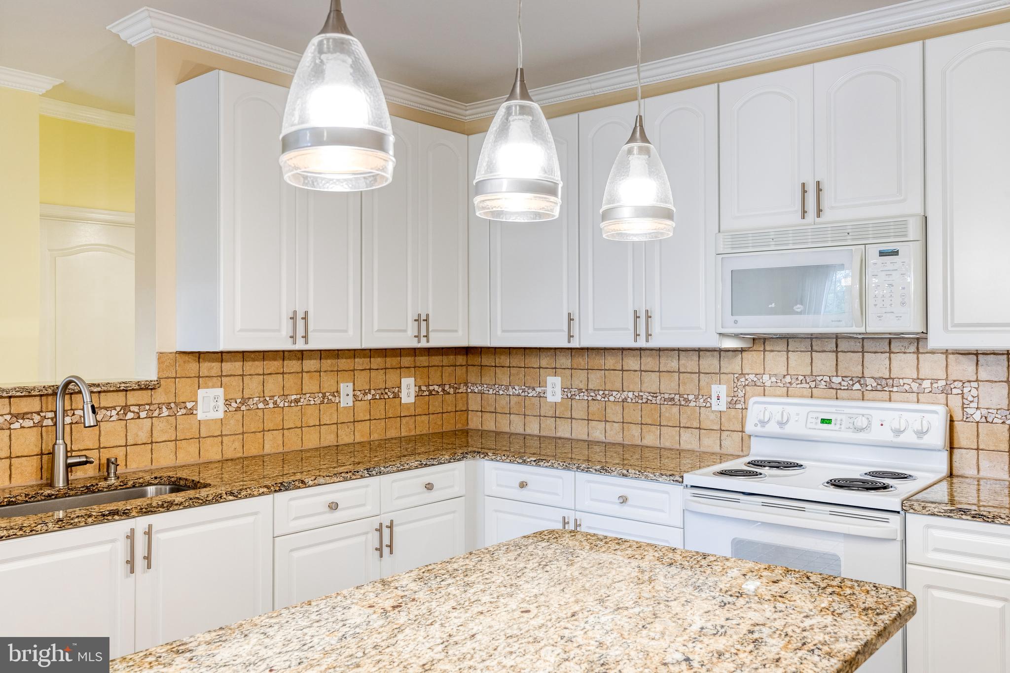 400 Symphony Circle, Unit 406 Hunt Valley, MD 21030 - Photo 11 of 37 a kitchen with granite countertop a sink a stove and cabinets