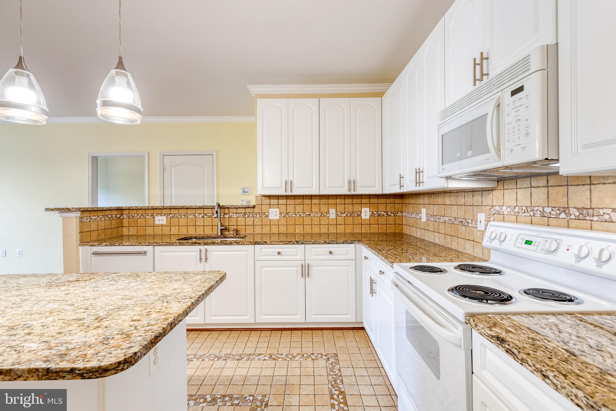 400 Symphony Circle, Unit 406 Hunt Valley, MD 21030 - Photo 12 of 37 a kitchen with a stove a sink and a refrigerator
