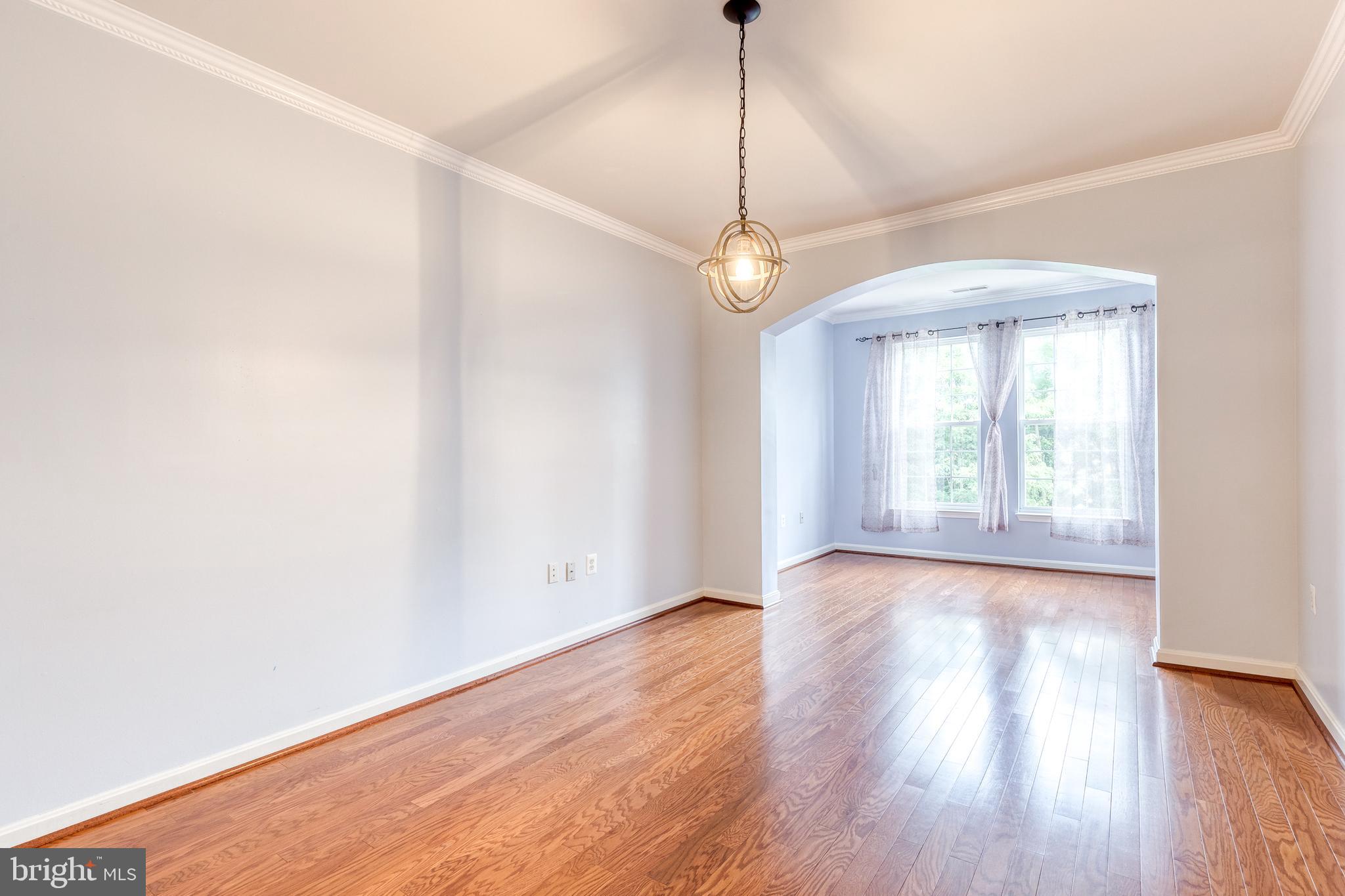 400 Symphony Circle, Unit 406 Hunt Valley, MD 21030 - Photo 16 of 37 a view of an empty room with wooden floor and a window