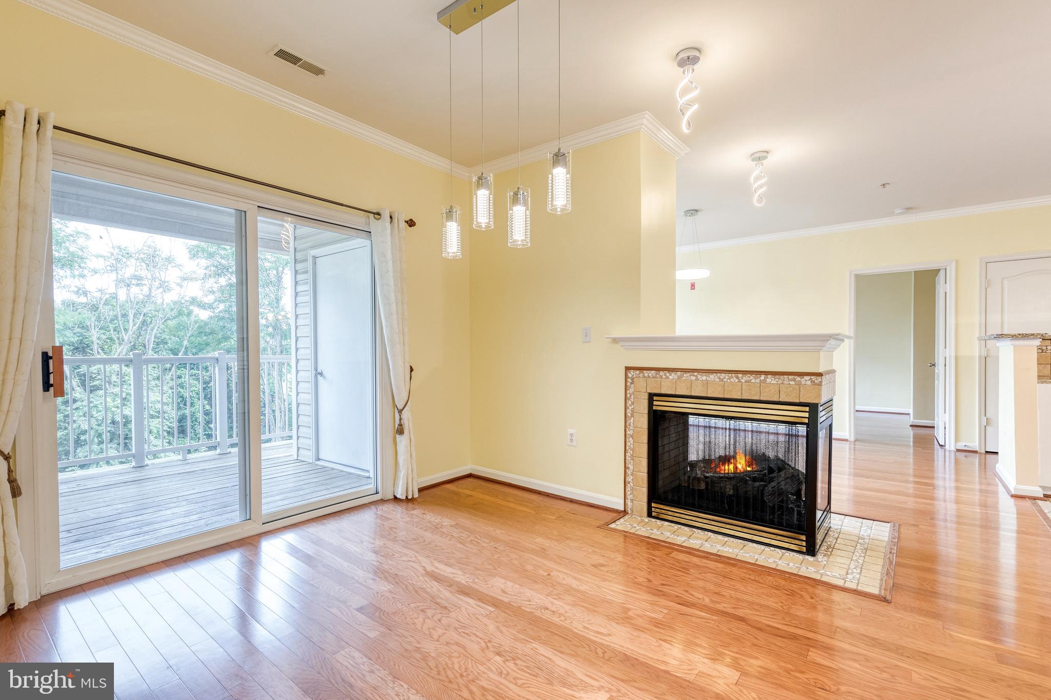 400 Symphony Circle, Unit 406 Hunt Valley, MD 21030 - Photo 2 of 37 a view of an empty room with wooden floor fireplace and a window