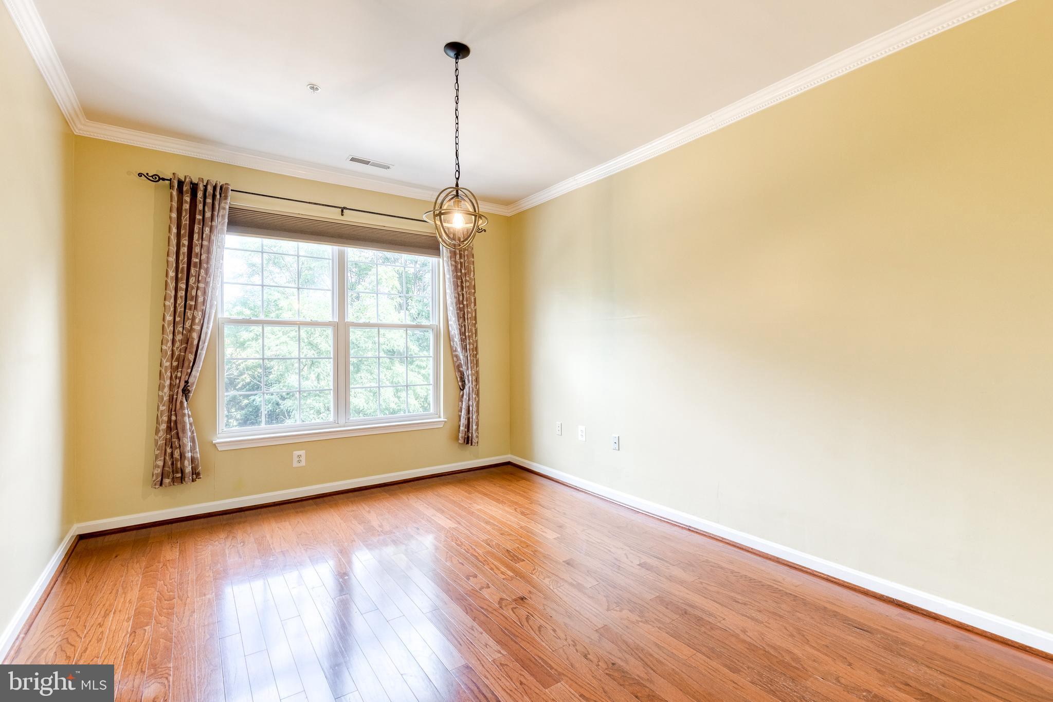 400 Symphony Circle, Unit 406 Hunt Valley, MD 21030 - Photo 22 of 37 a view of an empty room with wooden floor and a window