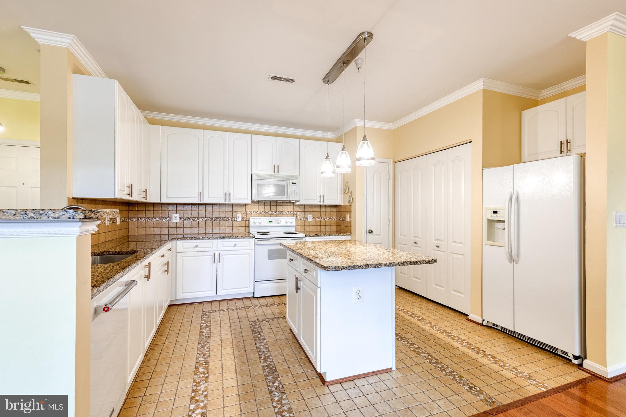 400 Symphony Circle, Unit 406 Hunt Valley, MD 21030 - Photo 9 of 37 a kitchen with a sink a counter top space stainless steel appliances and cabinets