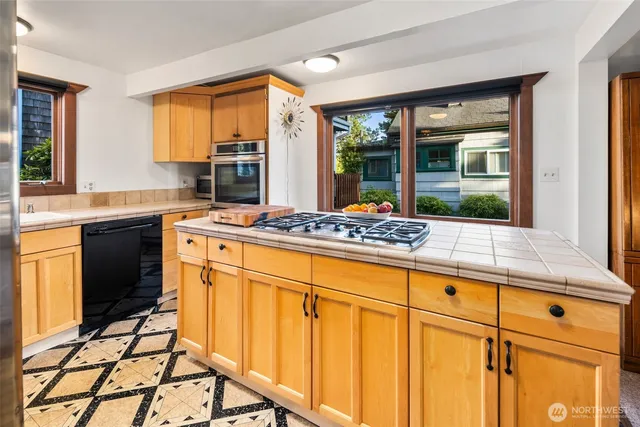 a kitchen with stainless steel appliances granite countertop a refrigerator and a stove