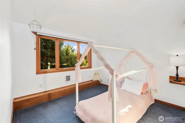 a bedroom with a bed and painting on the wall