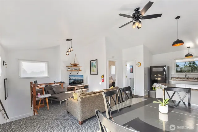 a living room with furniture kitchen view and a chandelier
