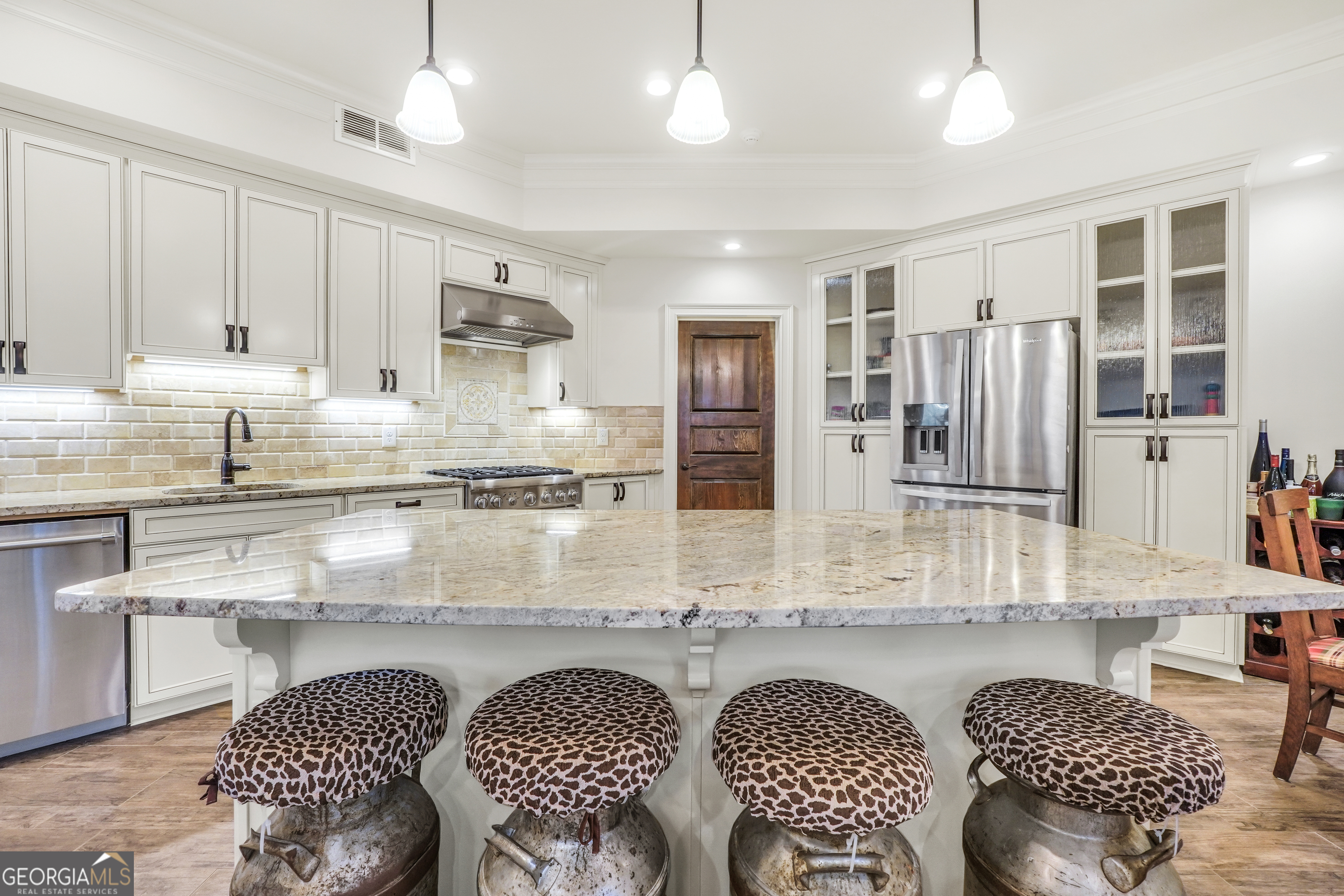 610 Elliott Road McDonough, GA 30252 - Photo 59 of 92 a kitchen with stainless steel appliances granite countertop a stove a sink dishwasher a dining table and chairs with wooden floor