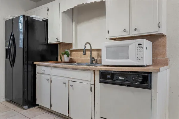 a kitchen with stainless steel appliances granite countertop white cabinets stove and a refrigerator