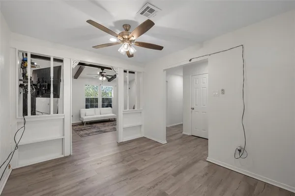 a view of a livingroom with wooden floor and a ceiling fan