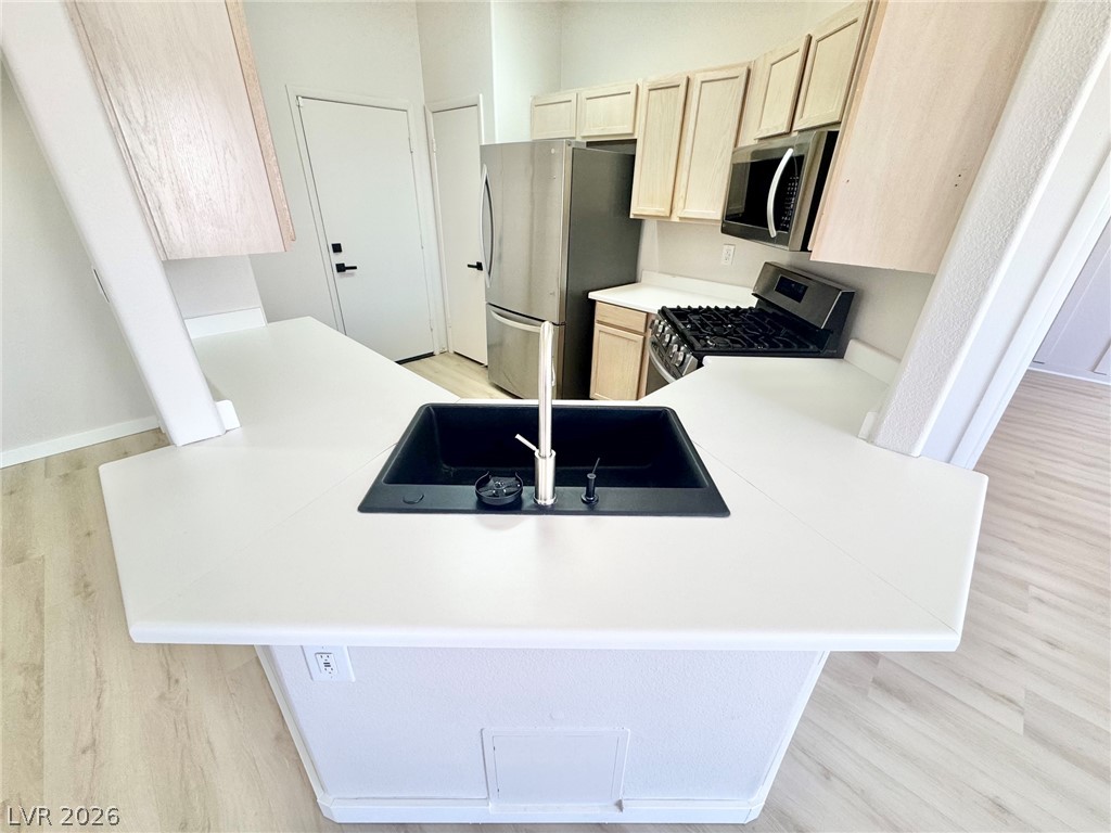 7340 Ridge Star Court Las Vegas, NV 89131 - Photo 3 of 22 A well-appointed kitchen features a central island with a sink, complementing the cabinetry and modern appliances.