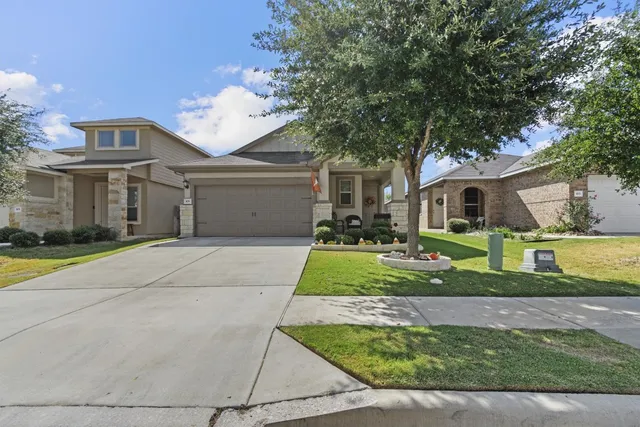 a front view of a house with a yard and garage
