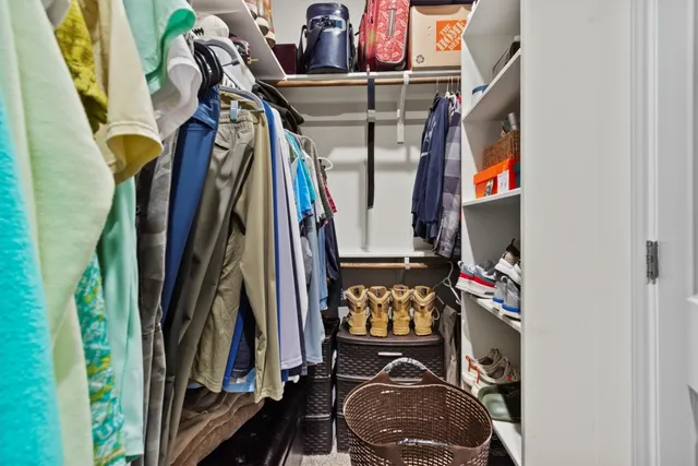 a view of walk in closet with clothes and shoes