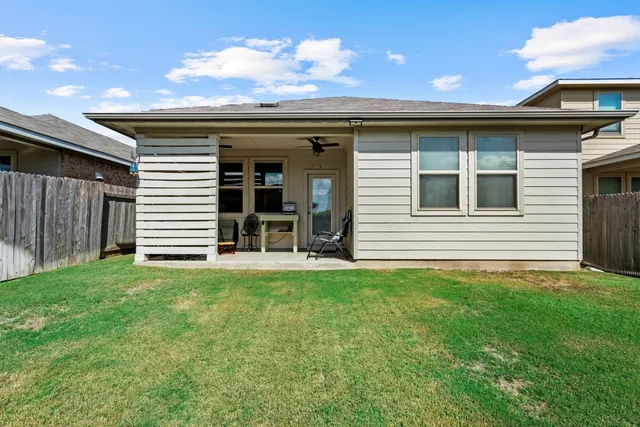 a backyard of a house with table and chairs