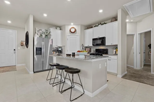 a kitchen with stainless steel appliances granite countertop a refrigerator and a stove top oven