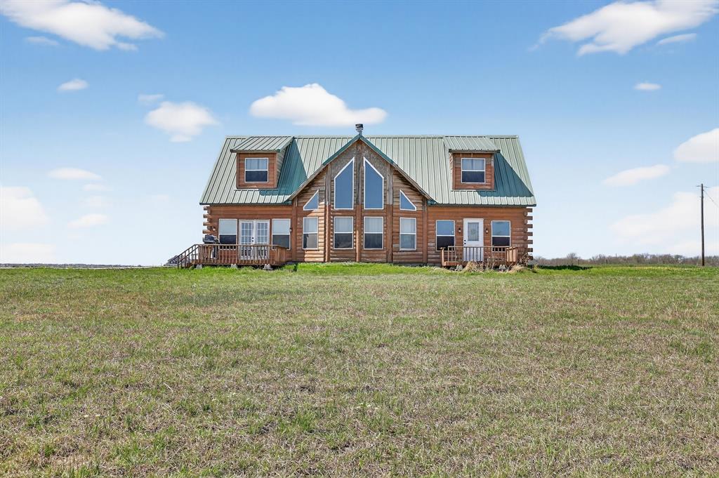 131 Hawk Ridge Decatur, TX 76234 - Photo 12 of 34 View of front facade featuring a front lawn, a metal roof, and log exterior