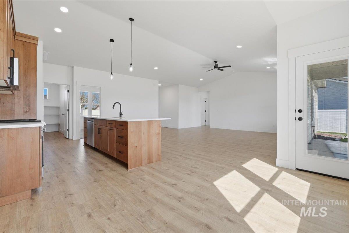 2175 Austin Way Fruitland, ID 83619 - Photo 30 of 30 Kitchen featuring decorative light fixtures, a kitchen island with sink, vaulted ceiling, open floor plan, and a ceiling fan