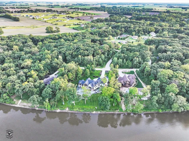 an aerial view of a house with a yard and lake view