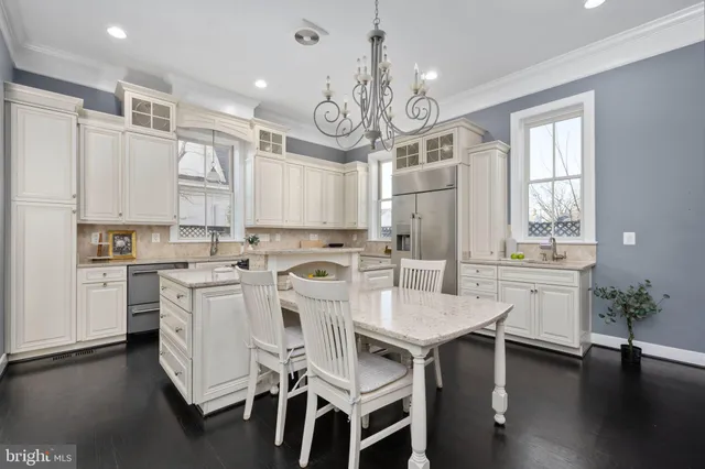 an empty room with wooden floor a ceiling fan and windows