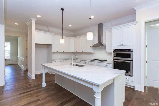 a kitchen with white cabinets a sink stove and refrigerator