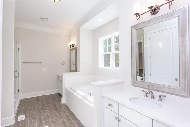 a en suite bathroom with a sink mirror and a shower