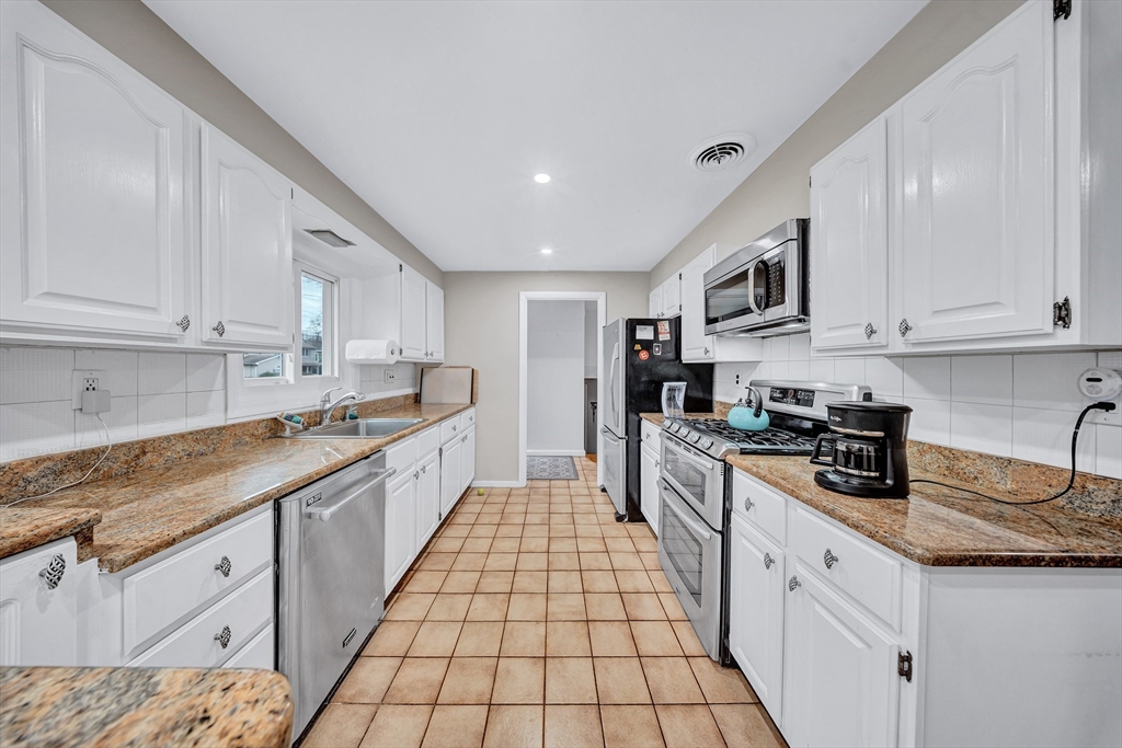 6 Woodward Road Framingham, MA 01701 - Photo 11 of 41 a large kitchen with stainless steel appliances granite countertop a sink and cabinets
