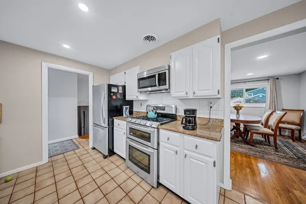 a kitchen with white cabinets and appliances