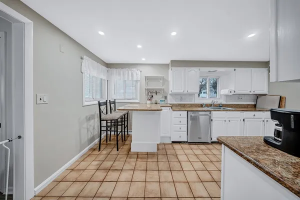 a kitchen with a sink a stove a microwave cabinets and a dining table