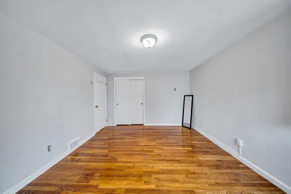 a view of a big room with wooden floor and natural light