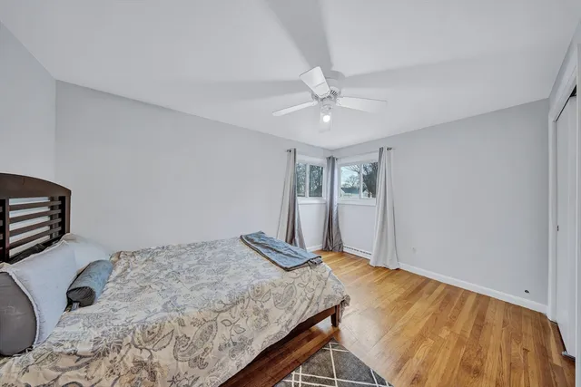 a bed sitting in a spacious bedroom next to a window