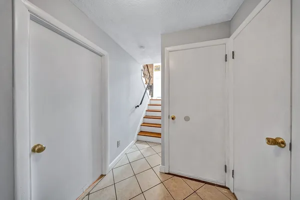 a view of a hallway with staircase and closet