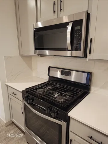 a kitchen with a refrigerator and a stove top oven