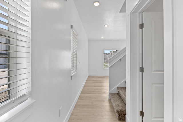 1269 West 500 South Logan, UT 84321 - Photo 2 of 19 Hallway with light wood-finish flooring, white walls, recessed lighting, and windows featuring horizontal blinds