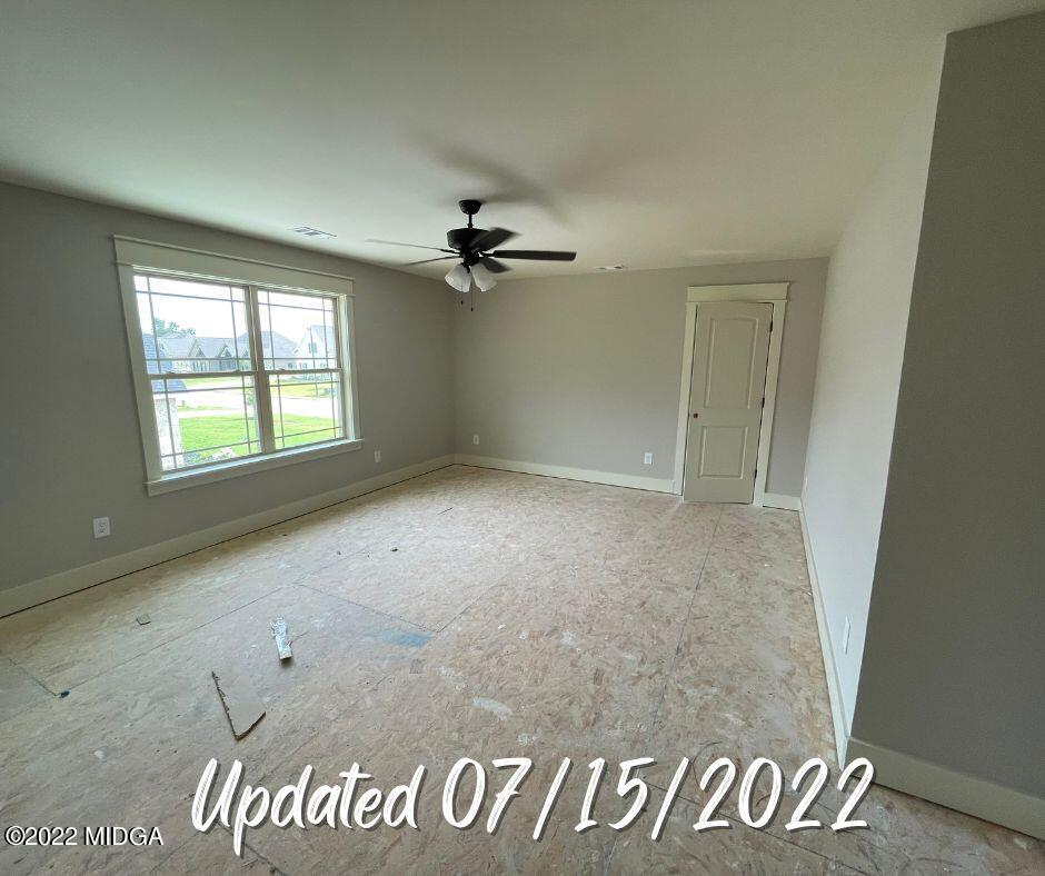 411 Stonegate Trail Perry, GA 31069 - Photo 10 of 14 an empty room with windows and ceiling fan
