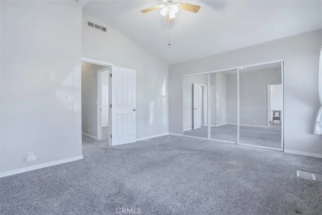 a view of an empty room with a chandelier fan