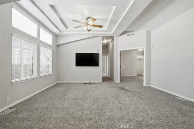 an empty room with windows and fireplace