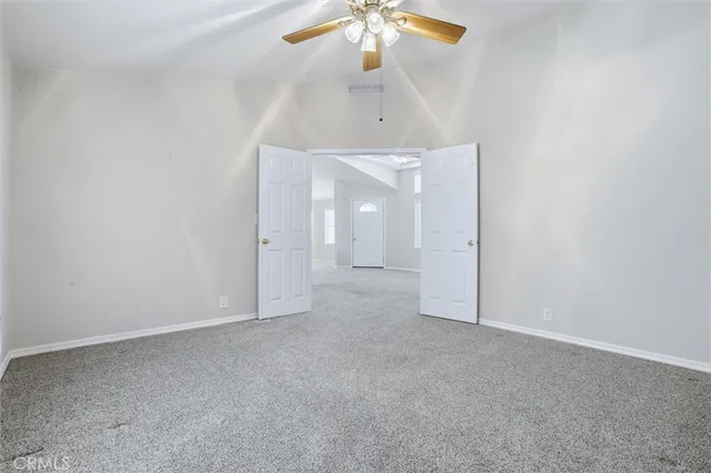 an empty room with chandelier fan