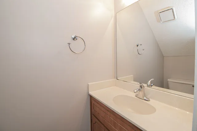 a view of a room with a hanging light and kitchen view