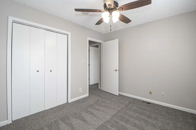 an empty room with a window and a fan
