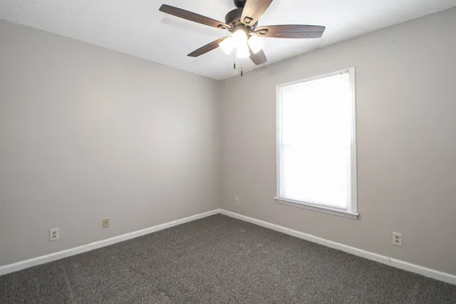 an empty room with a chandelier fan and a chandelier fan