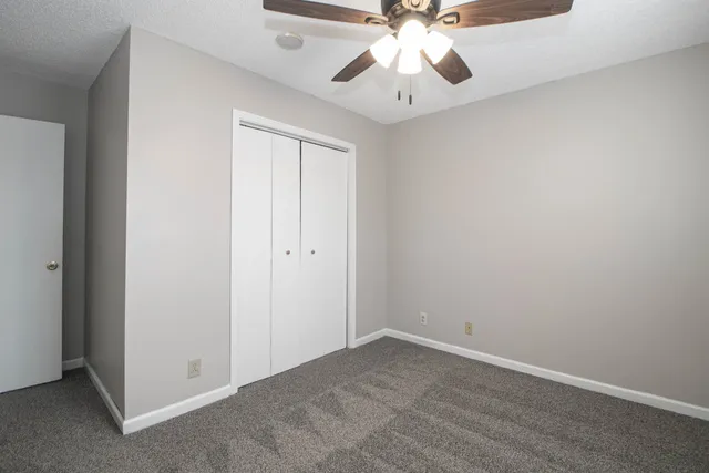 an empty room with a ceiling fan and a window